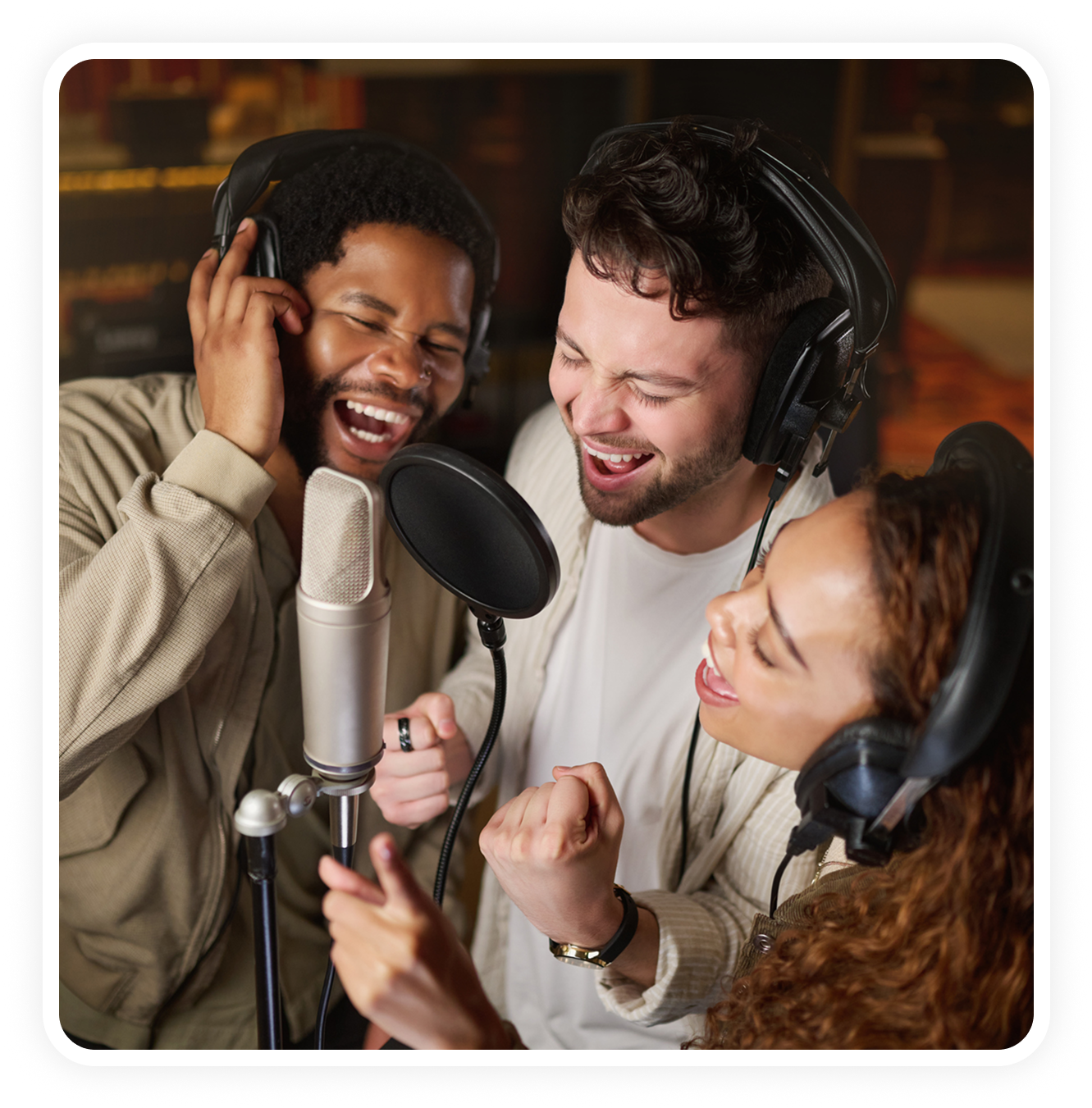 Three people joyfully singing in studio.